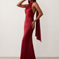 Woman wearing the Winnie satin halter maxi dress featuring a glossy satin finish, halter neckline with tie-back detail, open draped back, and a floor-length relaxed silhouette.