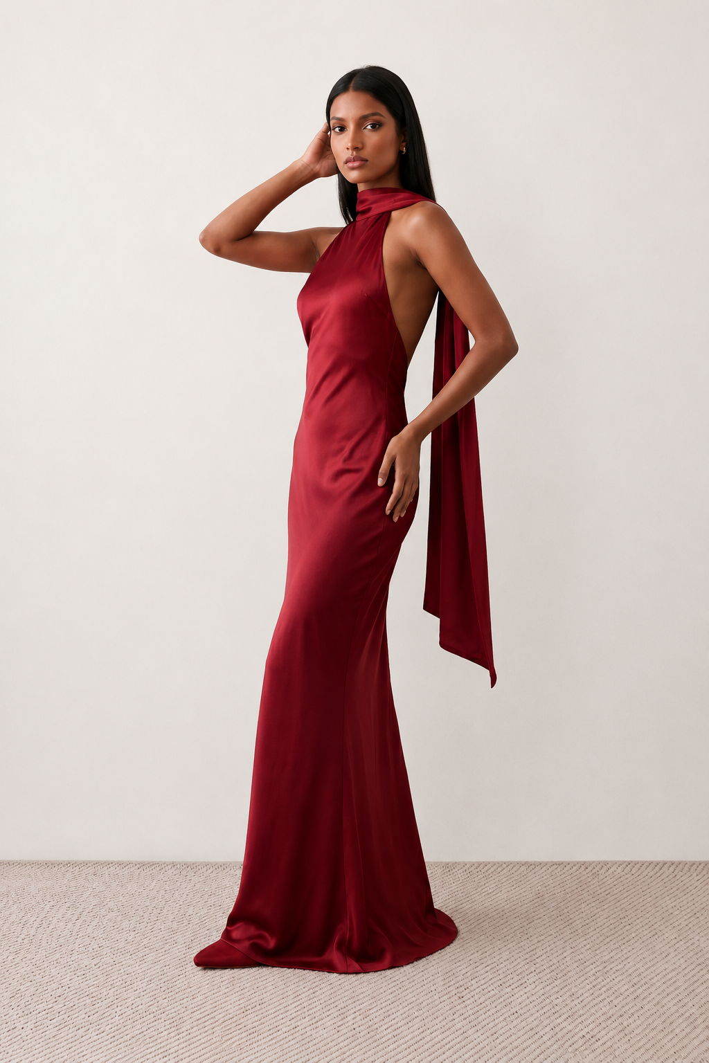 Woman wearing the Winnie satin halter maxi dress featuring a glossy satin finish, halter neckline with tie-back detail, open draped back, and a floor-length relaxed silhouette.