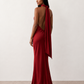 Woman wearing the Winnie satin halter maxi dress featuring a glossy satin finish, halter neckline with tie-back detail, open draped back, and a floor-length relaxed silhouette.