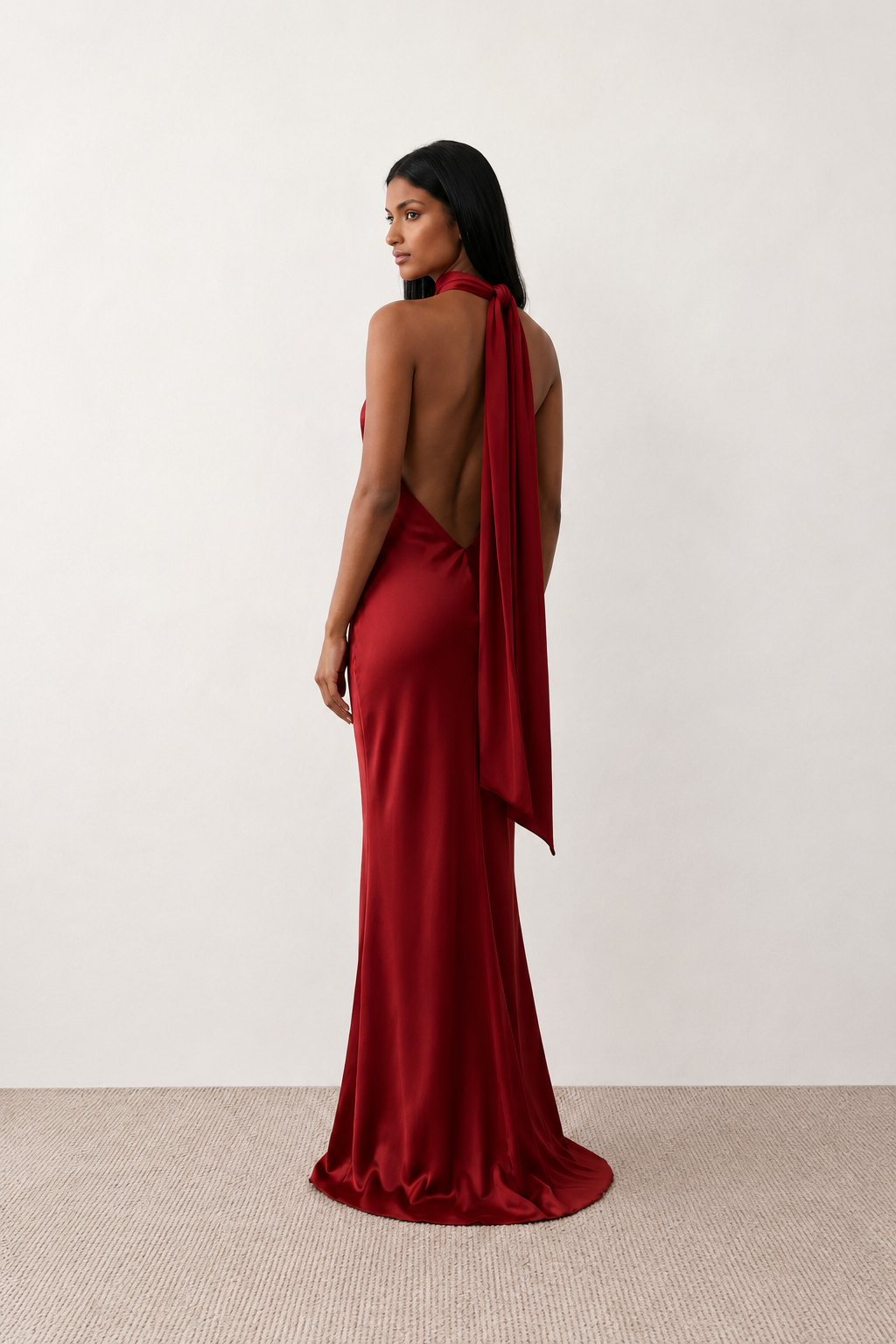Woman wearing the Winnie satin halter maxi dress featuring a glossy satin finish, halter neckline with tie-back detail, open draped back, and a floor-length relaxed silhouette.