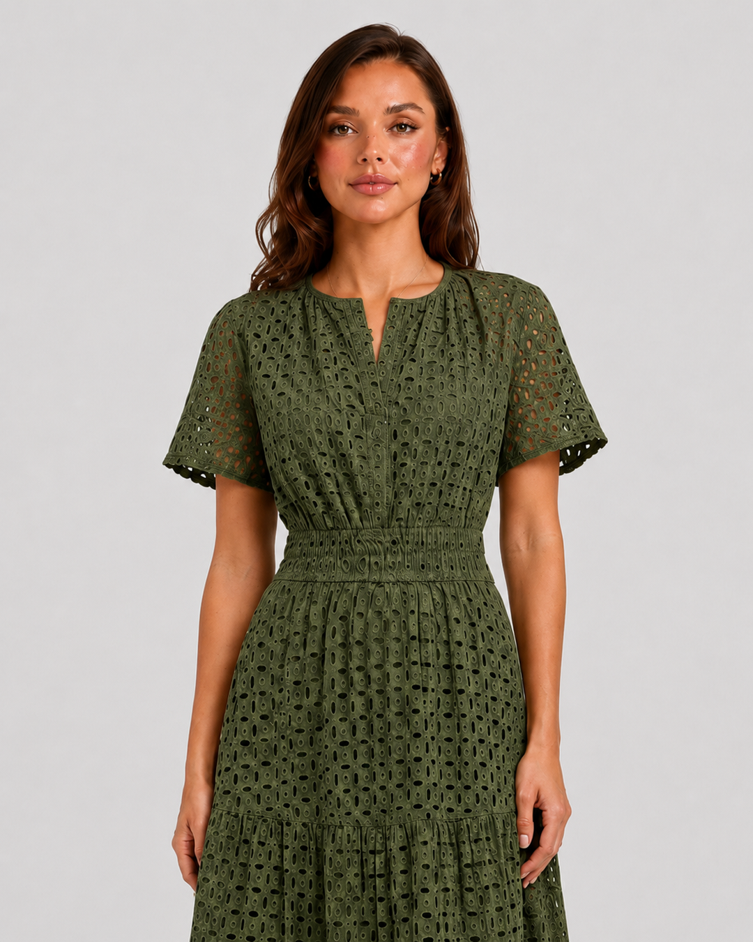 Woman wearing a white eyelet A-line midi dress with a softly defined waist, tiered skirt, and breathable cotton-blend fabric for summer occasions.