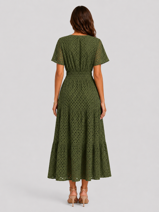 Woman wearing a white eyelet A-line midi dress with a softly defined waist, tiered skirt, and breathable cotton-blend fabric for summer occasions.