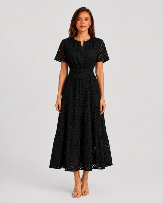 Woman wearing a white eyelet A-line midi dress with a softly defined waist, tiered skirt, and breathable cotton-blend fabric for summer occasions.