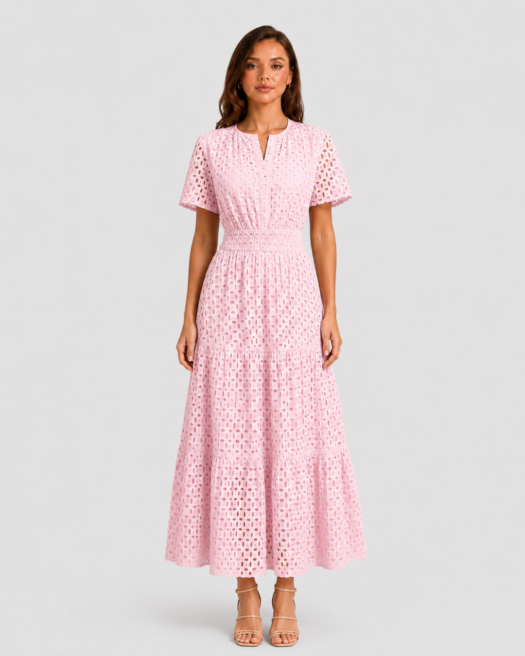 Woman wearing a white eyelet A-line midi dress with a softly defined waist, tiered skirt, and breathable cotton-blend fabric for summer occasions.