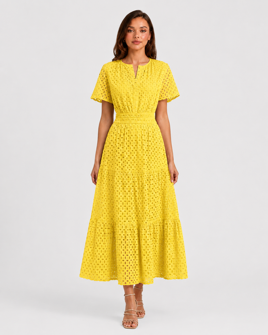 Woman wearing a white eyelet A-line midi dress with a softly defined waist, tiered skirt, and breathable cotton-blend fabric for summer occasions.