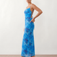 Seren spaghetti strap maxi dress in an abstract floral print featuring a square neckline, thin straps, a low lace-up open back, a shirred waist, and a fitted floor-length silhouette.