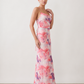 Seren spaghetti strap maxi dress in an abstract floral print featuring a square neckline, thin straps, a low lace-up open back, a shirred waist, and a fitted floor-length silhouette.