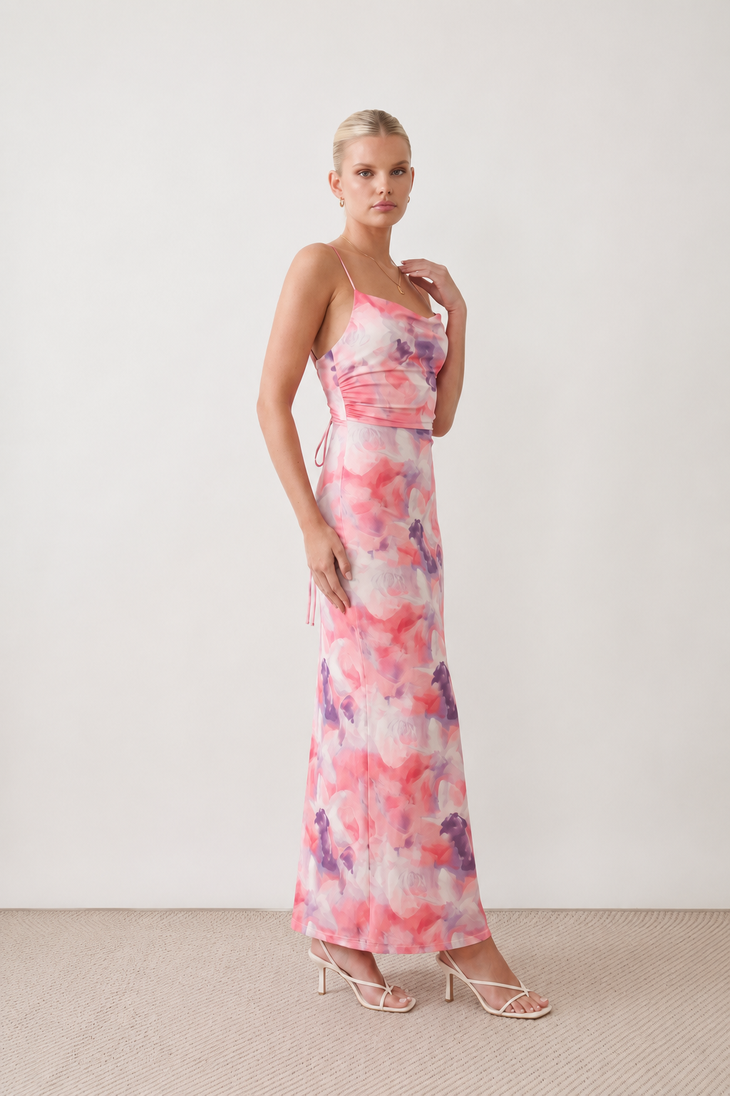 Seren spaghetti strap maxi dress in an abstract floral print featuring a square neckline, thin straps, a low lace-up open back, a shirred waist, and a fitted floor-length silhouette.