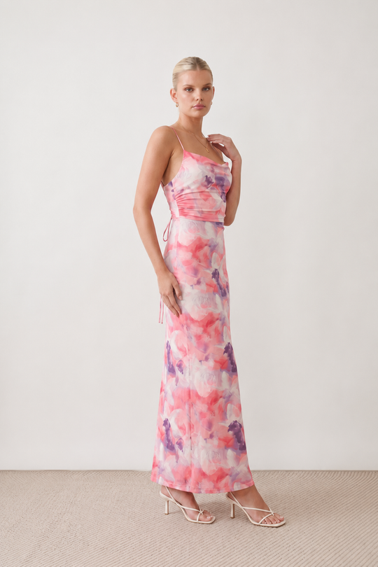 Seren spaghetti strap maxi dress in an abstract floral print featuring a square neckline, thin straps, a low lace-up open back, a shirred waist, and a fitted floor-length silhouette.