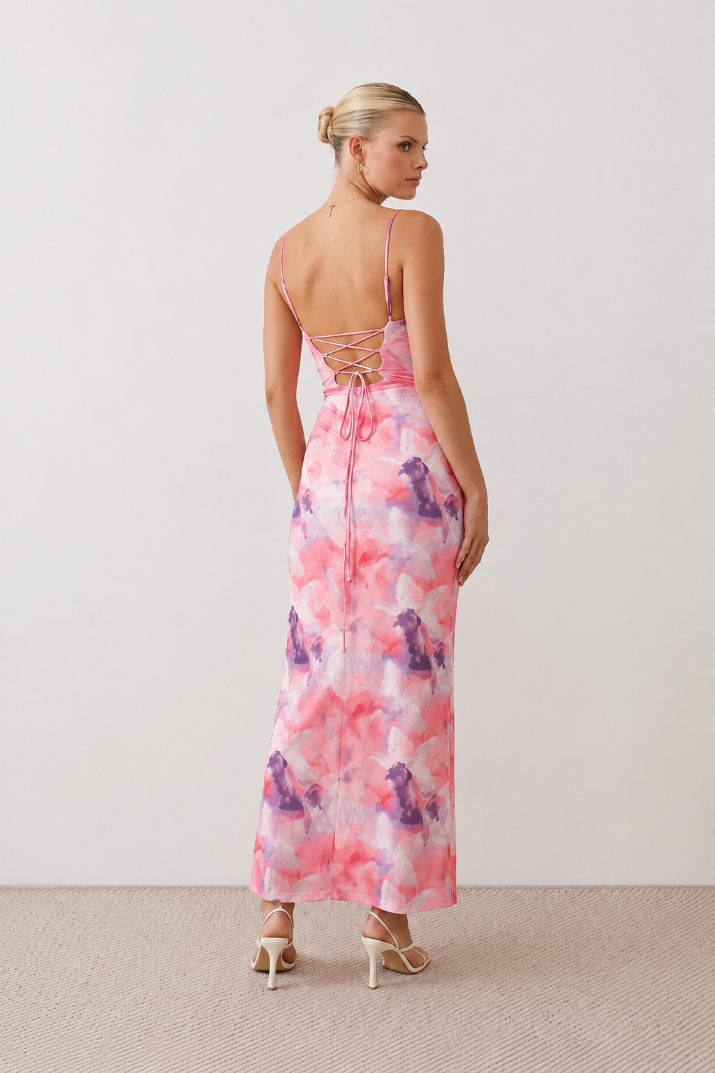 Seren spaghetti strap maxi dress in an abstract floral print featuring a square neckline, thin straps, a low lace-up open back, a shirred waist, and a fitted floor-length silhouette.