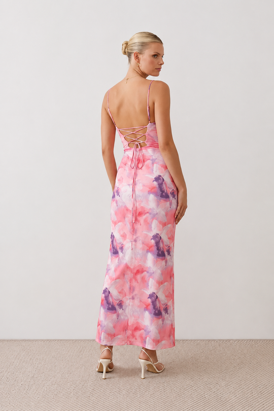 Seren spaghetti strap maxi dress in an abstract floral print featuring a square neckline, thin straps, a low lace-up open back, a shirred waist, and a fitted floor-length silhouette.