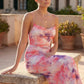 Seren spaghetti strap maxi dress in an abstract floral print featuring a square neckline, thin straps, a low lace-up open back, a shirred waist, and a fitted floor-length silhouette.