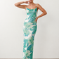 Seren spaghetti strap maxi dress in an abstract floral print featuring a square neckline, thin straps, a low lace-up open back, a shirred waist, and a fitted floor-length silhouette.