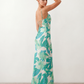 Seren spaghetti strap maxi dress in an abstract floral print featuring a square neckline, thin straps, a low lace-up open back, a shirred waist, and a fitted floor-length silhouette.