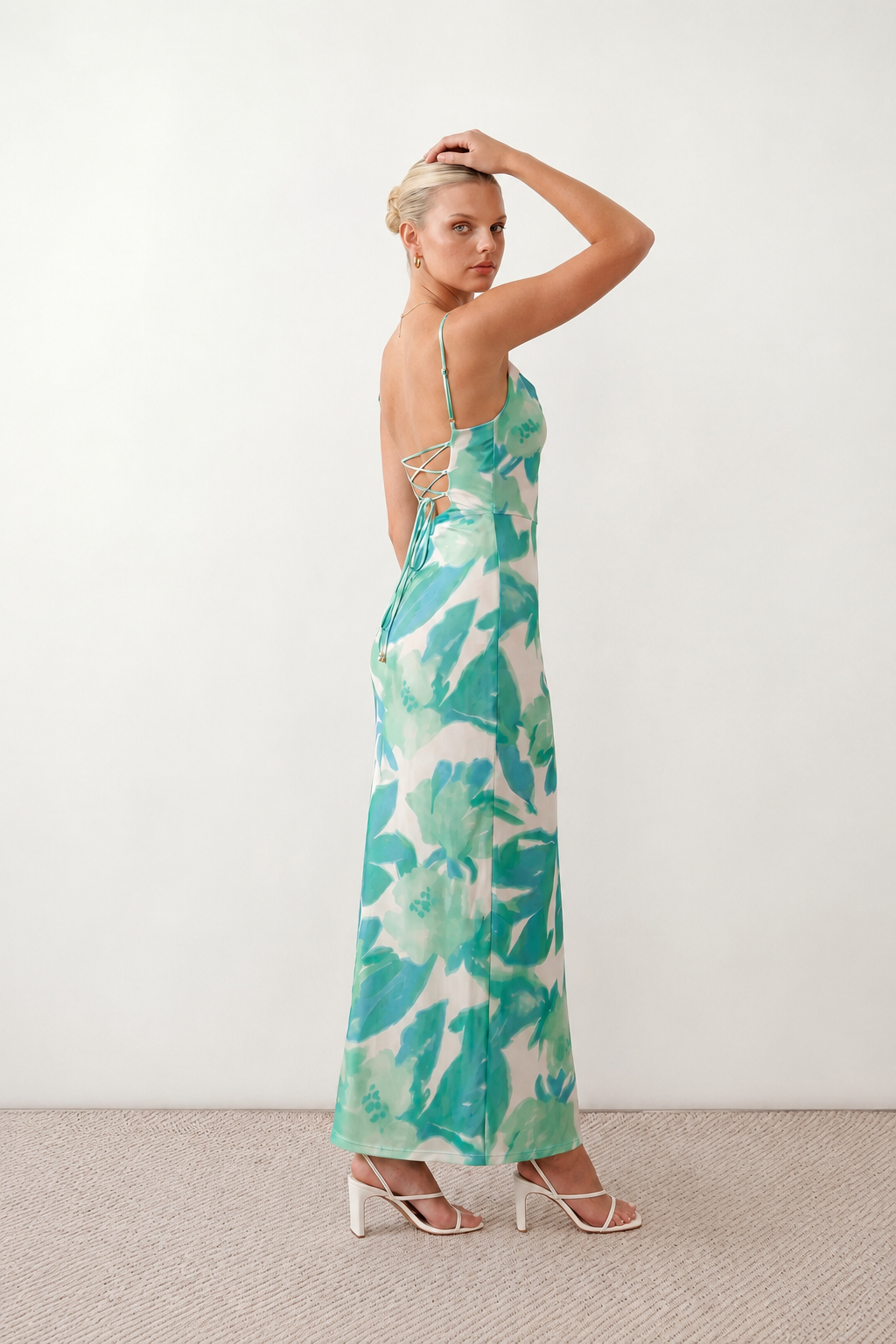 Seren spaghetti strap maxi dress in an abstract floral print featuring a square neckline, thin straps, a low lace-up open back, a shirred waist, and a fitted floor-length silhouette.