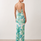 Seren spaghetti strap maxi dress in an abstract floral print featuring a square neckline, thin straps, a low lace-up open back, a shirred waist, and a fitted floor-length silhouette.