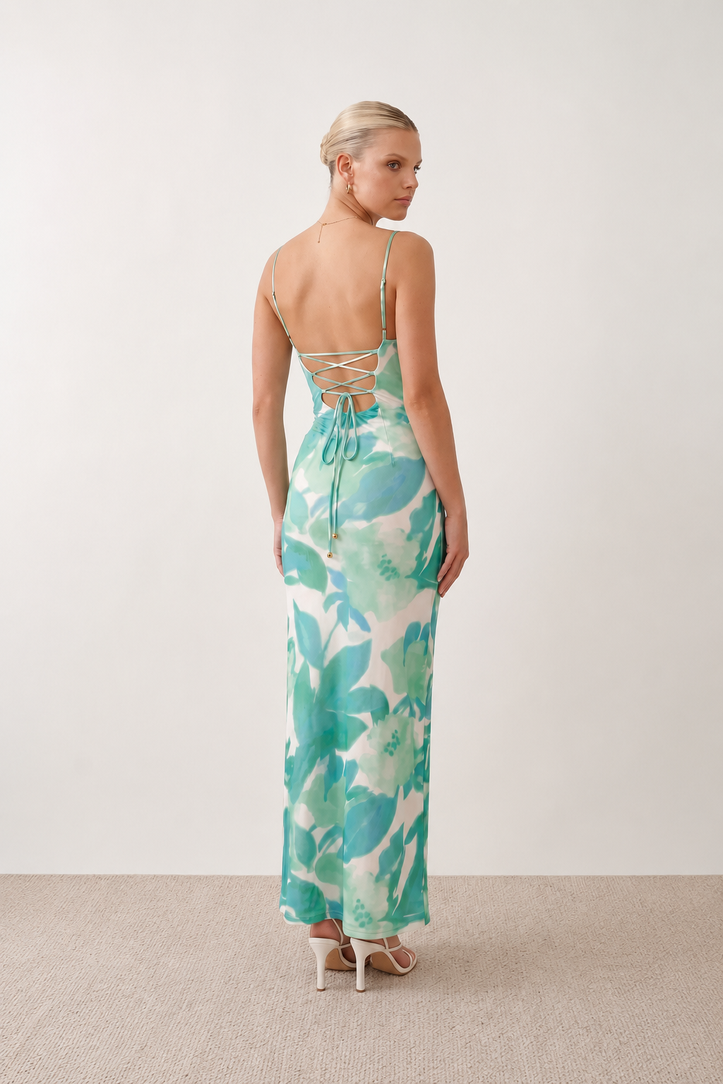 Seren spaghetti strap maxi dress in an abstract floral print featuring a square neckline, thin straps, a low lace-up open back, a shirred waist, and a fitted floor-length silhouette.