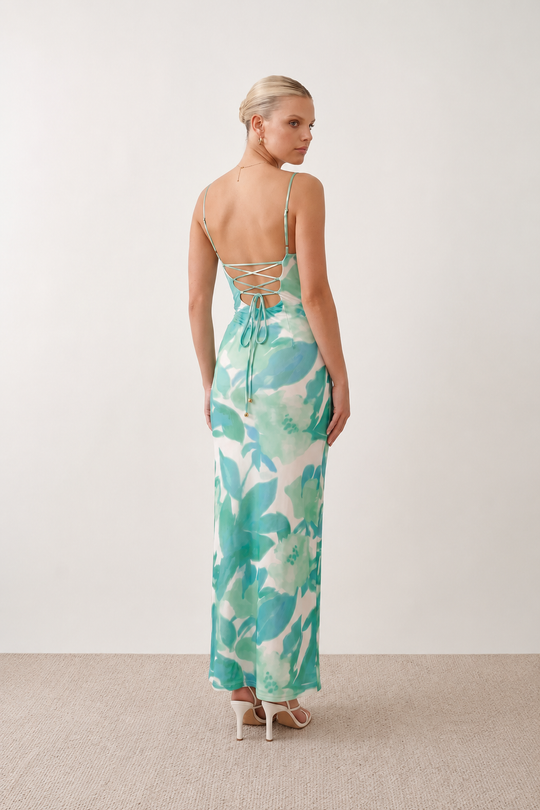 Seren spaghetti strap maxi dress in an abstract floral print featuring a square neckline, thin straps, a low lace-up open back, a shirred waist, and a fitted floor-length silhouette.