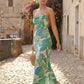 Seren spaghetti strap maxi dress in an abstract floral print featuring a square neckline, thin straps, a low lace-up open back, a shirred waist, and a fitted floor-length silhouette.
