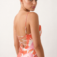 Seren spaghetti strap maxi dress in an abstract floral print featuring a square neckline, thin straps, a low lace-up open back, a shirred waist, and a fitted floor-length silhouette.