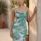 Seren spaghetti strap maxi dress in an abstract floral print featuring a square neckline, thin straps, a low lace-up open back, a shirred waist, and a fitted floor-length silhouette.