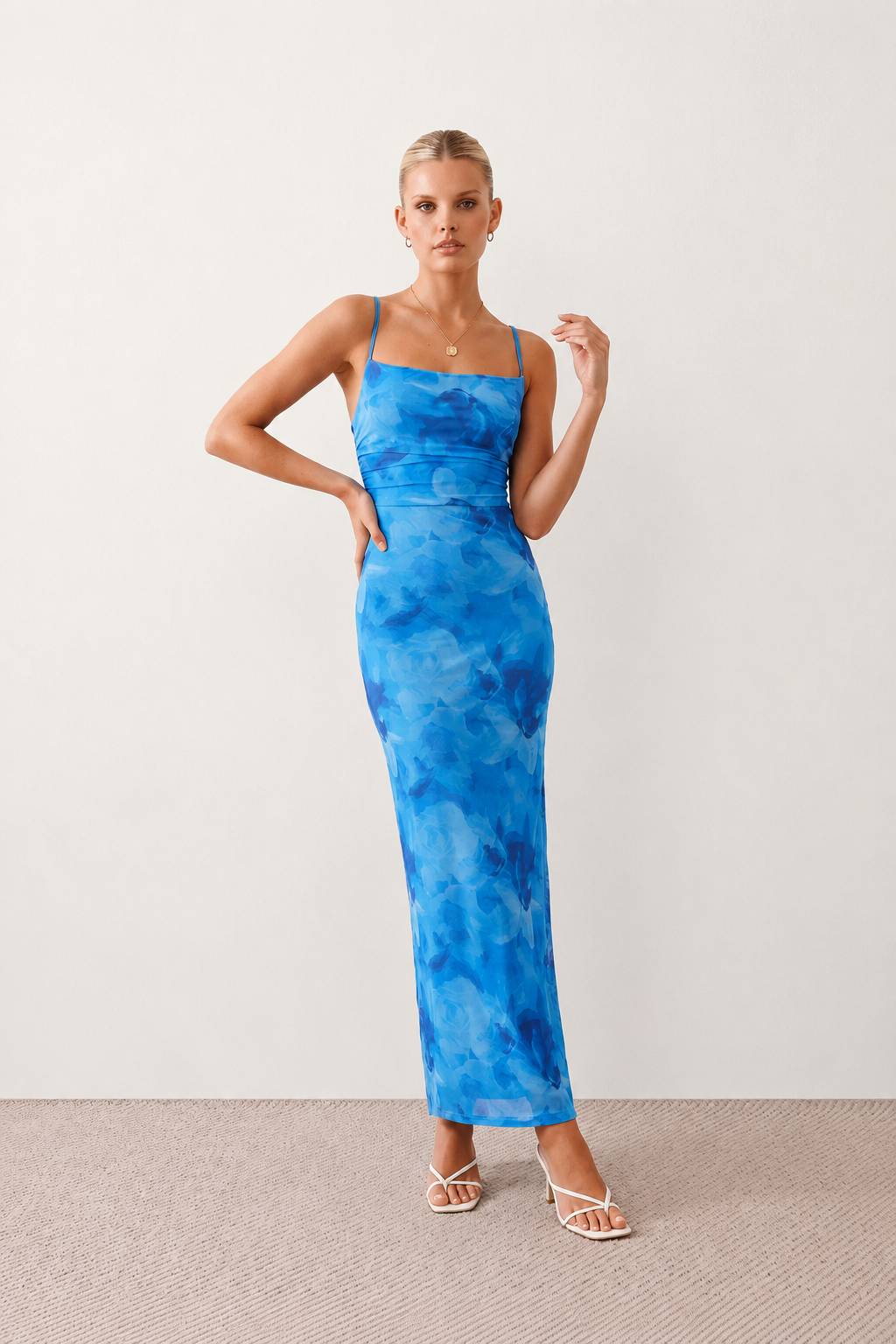 Seren spaghetti strap maxi dress in an abstract floral print featuring a square neckline, thin straps, a low lace-up open back, a shirred waist, and a fitted floor-length silhouette.