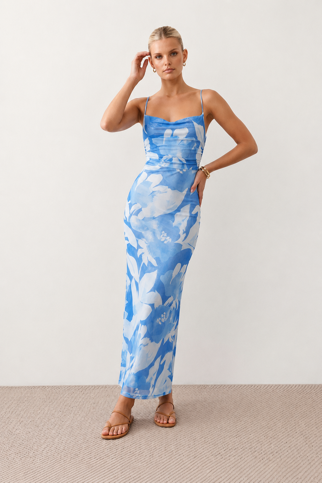 Seren spaghetti strap maxi dress in an abstract floral print featuring a square neckline, thin straps, a low lace-up open back, a shirred waist, and a fitted floor-length silhouette.