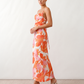 Seren spaghetti strap maxi dress in an abstract floral print featuring a square neckline, thin straps, a low lace-up open back, a shirred waist, and a fitted floor-length silhouette.