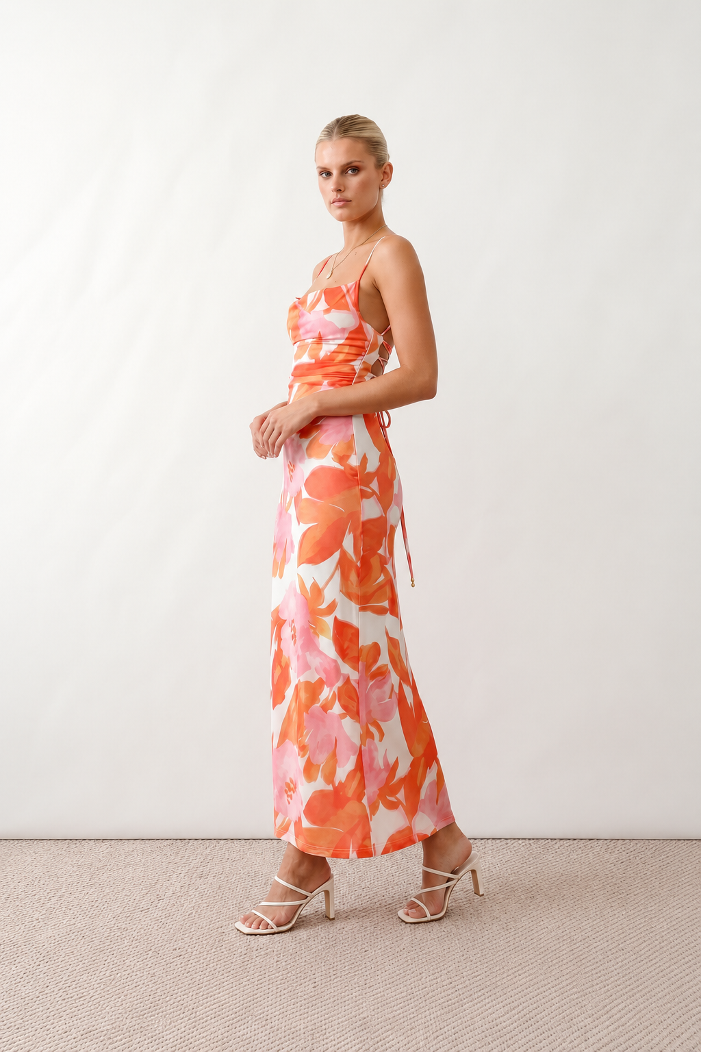 Seren spaghetti strap maxi dress in an abstract floral print featuring a square neckline, thin straps, a low lace-up open back, a shirred waist, and a fitted floor-length silhouette.