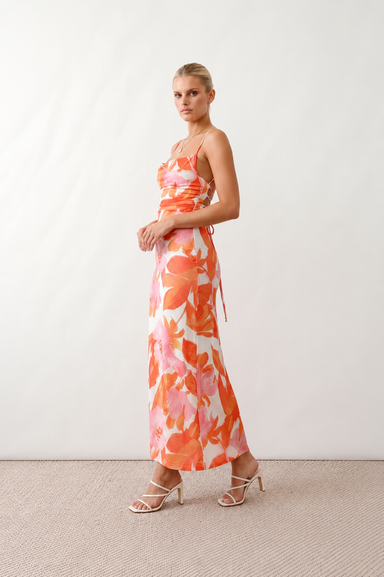 Seren spaghetti strap maxi dress in an abstract floral print featuring a square neckline, thin straps, a low lace-up open back, a shirred waist, and a fitted floor-length silhouette.