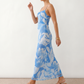 Seren spaghetti strap maxi dress in an abstract floral print featuring a square neckline, thin straps, a low lace-up open back, a shirred waist, and a fitted floor-length silhouette.