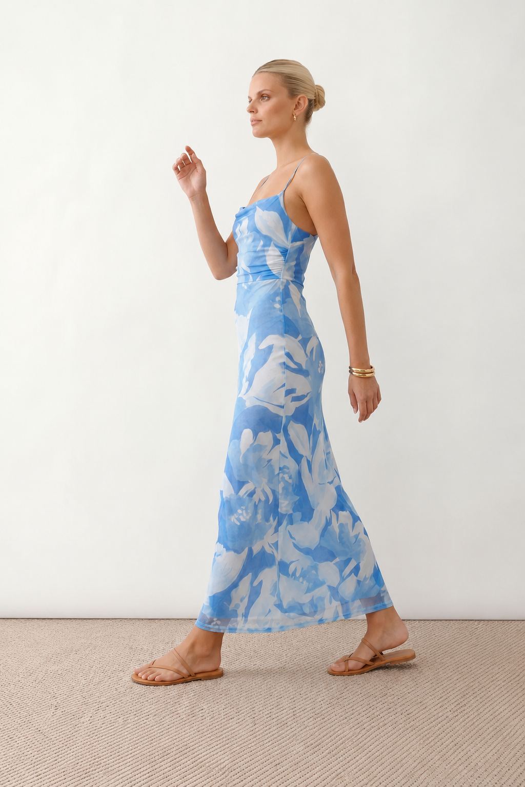Seren spaghetti strap maxi dress in an abstract floral print featuring a square neckline, thin straps, a low lace-up open back, a shirred waist, and a fitted floor-length silhouette.