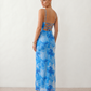 Seren spaghetti strap maxi dress in an abstract floral print featuring a square neckline, thin straps, a low lace-up open back, a shirred waist, and a fitted floor-length silhouette.