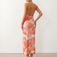 Seren spaghetti strap maxi dress in an abstract floral print featuring a square neckline, thin straps, a low lace-up open back, a shirred waist, and a fitted floor-length silhouette.