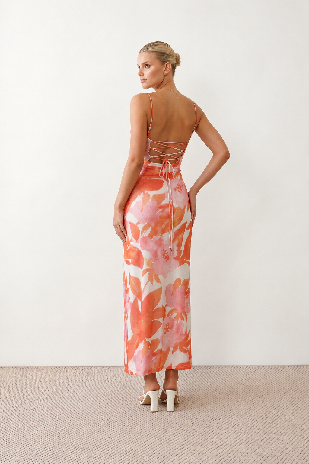 Seren spaghetti strap maxi dress in an abstract floral print featuring a square neckline, thin straps, a low lace-up open back, a shirred waist, and a fitted floor-length silhouette.