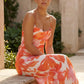 Seren spaghetti strap maxi dress in an abstract floral print featuring a square neckline, thin straps, a low lace-up open back, a shirred waist, and a fitted floor-length silhouette.