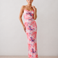 Seren spaghetti strap maxi dress in an abstract floral print featuring a square neckline, thin straps, a low lace-up open back, a shirred waist, and a fitted floor-length silhouette.
