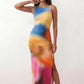 Woman wearing the abstract print side slit maxi dress in a vibrant multicolour tie-dye design, featuring a sleeveless round neckline, body-skimming column silhouette, thigh-high side slit, and full-length flowing skirt, ideal for summer holidays, weddings, and occasion wear.