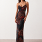 Woman wearing the Adelia Slip Spaghetti Strap Maxi Dress featuring a softly draped cowl neckline, delicate spaghetti straps, an open tie-back design and a flowing straight maxi skirt, styled for elegant evening occasions.