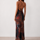 Woman wearing the Adelia Slip Spaghetti Strap Maxi Dress featuring a softly draped cowl neckline, delicate spaghetti straps, an open tie-back design and a flowing straight maxi skirt, styled for elegant evening occasions.