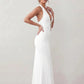 Woman wearing the Ariadna Mermaid Halter Maxi Dress featuring a deep plunge halter neckline, open back with adjustable tie fastening, gold-tone hardware at the ruched waist, subtle waist cut-out and a floor-length mermaid silhouette, ideal for weddings, black-tie events and formal evening occasions.
