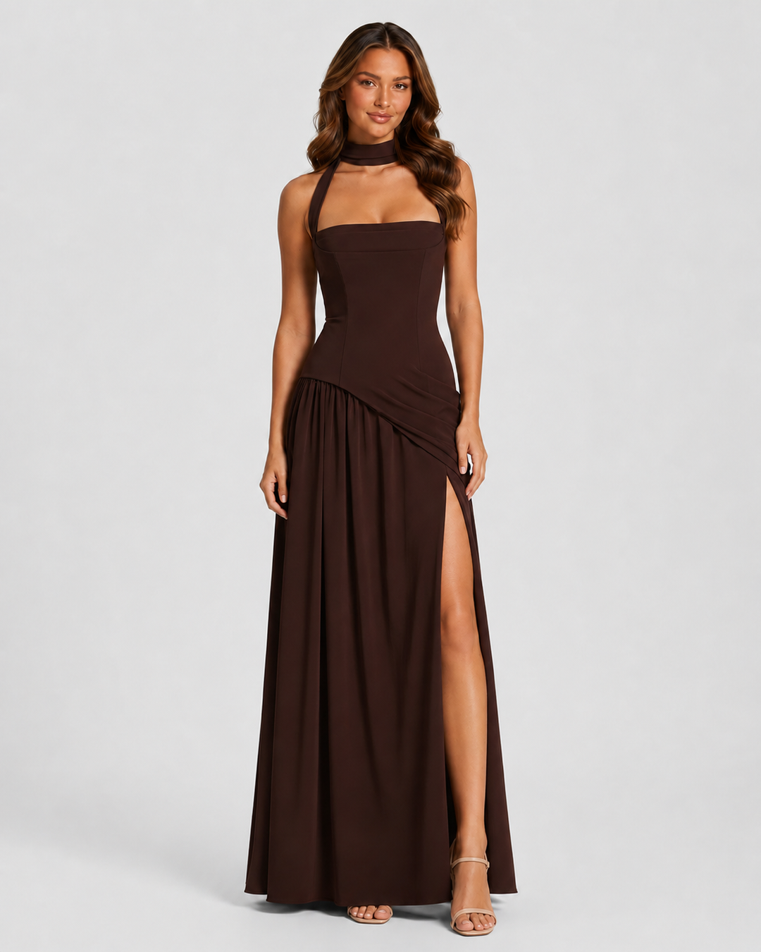 Woman wearing a satin-feel maxi dress with a sculpted bodice, asymmetric draped skirt, elegant side slit, and soft sheen for formal evening occasions.