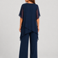 Women's chiffon-style two-piece set featuring an asymmetrical layered top and flowing wide-leg trousers in a relaxed elegant silhouette.