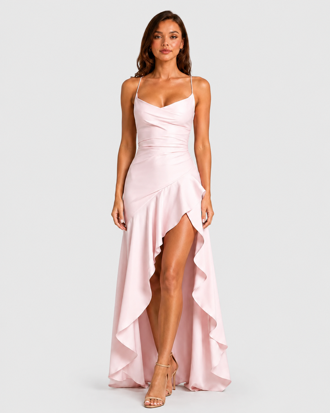Woman wearing a strappy maxi dress with asymmetrical hem, flowing skirt and thigh-high split in a lightweight draped fabric for elegant evening occasions.