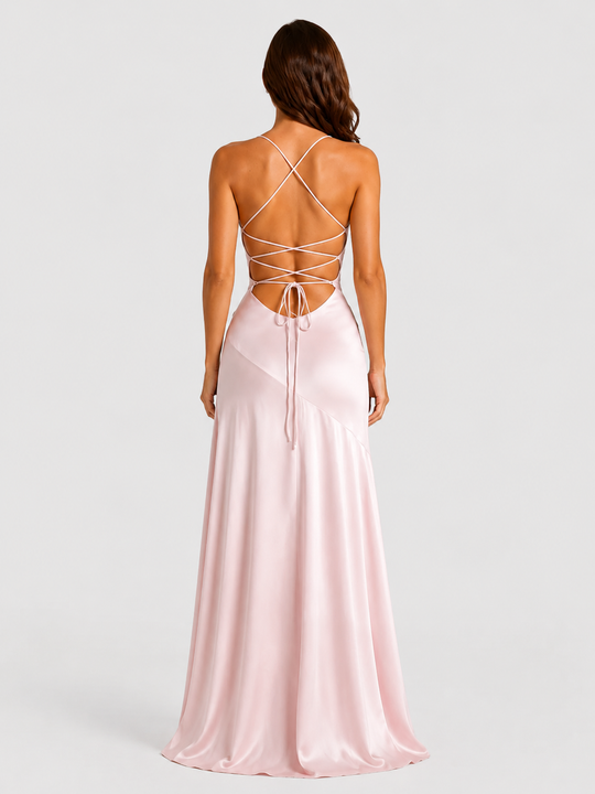 Woman wearing a strappy maxi dress with asymmetrical hem, flowing skirt and thigh-high split in a lightweight draped fabric for elegant evening occasions.