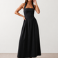 Aurora basque waist halter maxi dress with a halter neckline, open back, defined basque waist, and flowing A-line skirt in smooth fabric, ideal for weddings, formal events, and evening occasions.