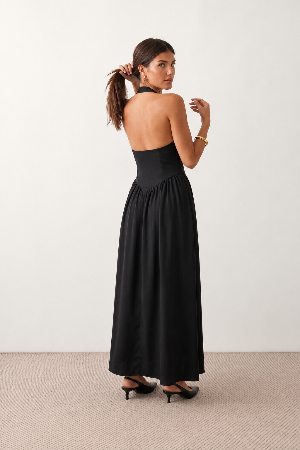 Aurora basque waist halter maxi dress with a halter neckline, open back, defined basque waist, and flowing A-line skirt in smooth fabric, ideal for weddings, formal events, and evening occasions.