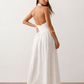 Aurora basque waist halter maxi dress with a halter neckline, open back, defined basque waist, and flowing A-line skirt in smooth fabric, ideal for weddings, formal events, and evening occasions.