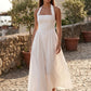 Aurora basque waist halter maxi dress with a halter neckline, open back, defined basque waist, and flowing A-line skirt in smooth fabric, ideal for weddings, formal events, and evening occasions.