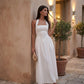 Aurora basque waist halter maxi dress with a halter neckline, open back, defined basque waist, and flowing A-line skirt in smooth fabric, ideal for weddings, formal events, and evening occasions.